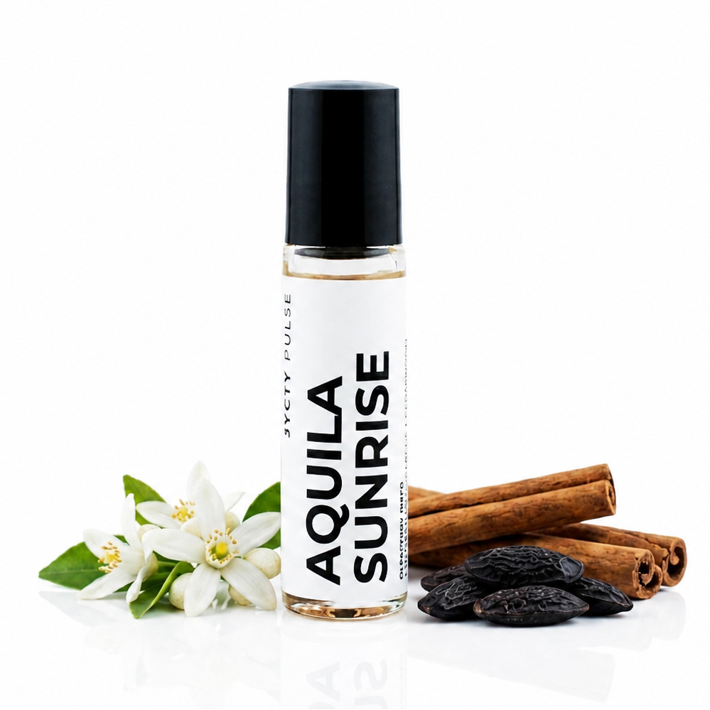 A clear glass roll-on bottle labeled 'AQUILA SUNRISE' with a black cap, styled with white citrus flowers, cinnamon sticks, and dark raisins on a clean white background.