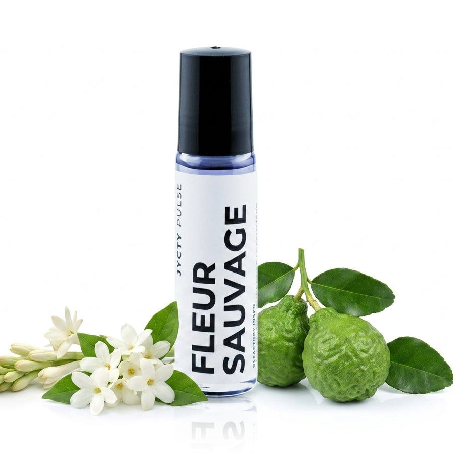 A bottle of FLEUR SAUVAGE roll-on perfume by JYCTY, styled with white jasmine flowers and green kumquats on a clean white background.