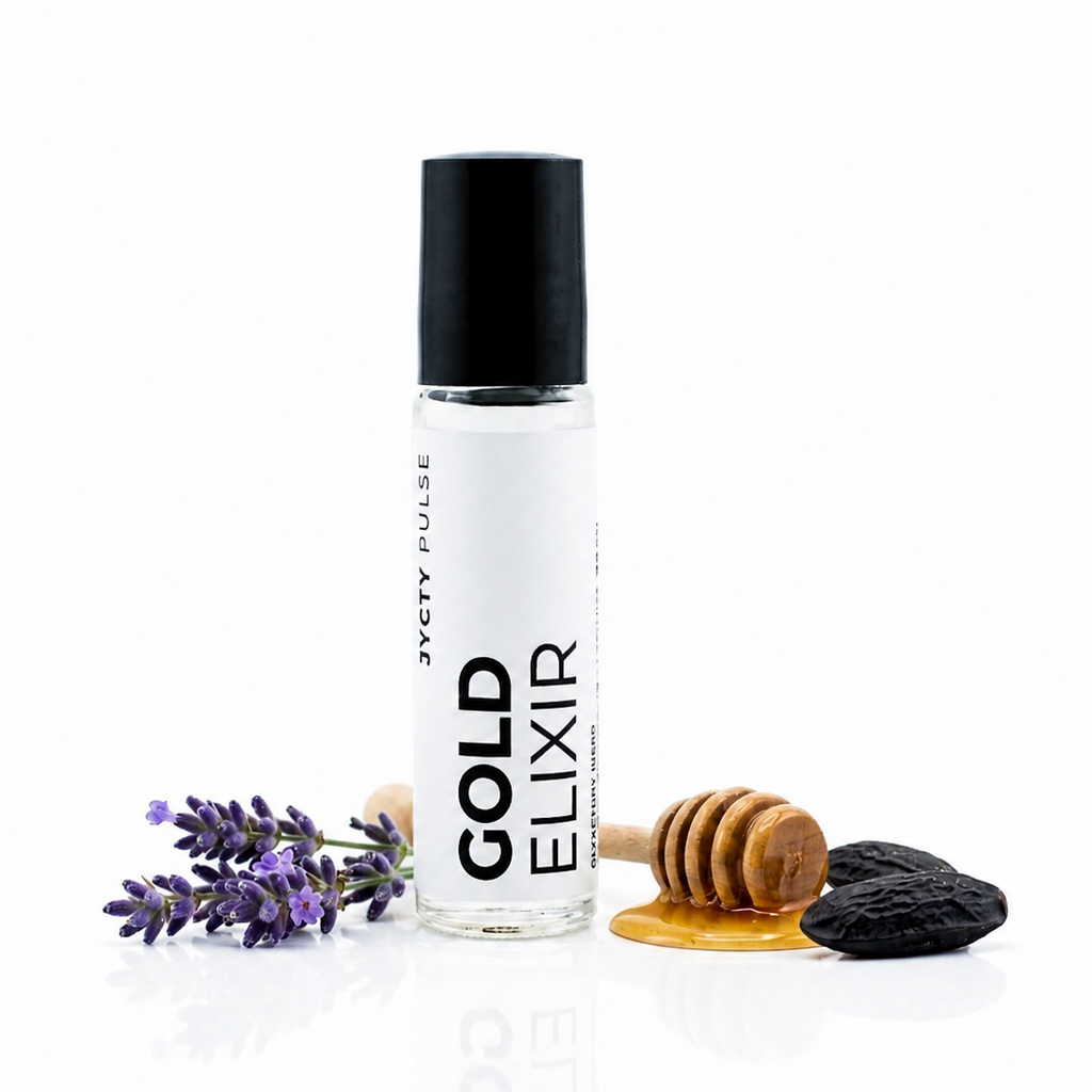 A clear glass roller bottle with a black cap labeled 'GOLD ELIXIR' BY 'JYCTY PULSE' vertically, styled with lavender sprigs, a wooden honey dipper, and a dark stone on a clean white background.