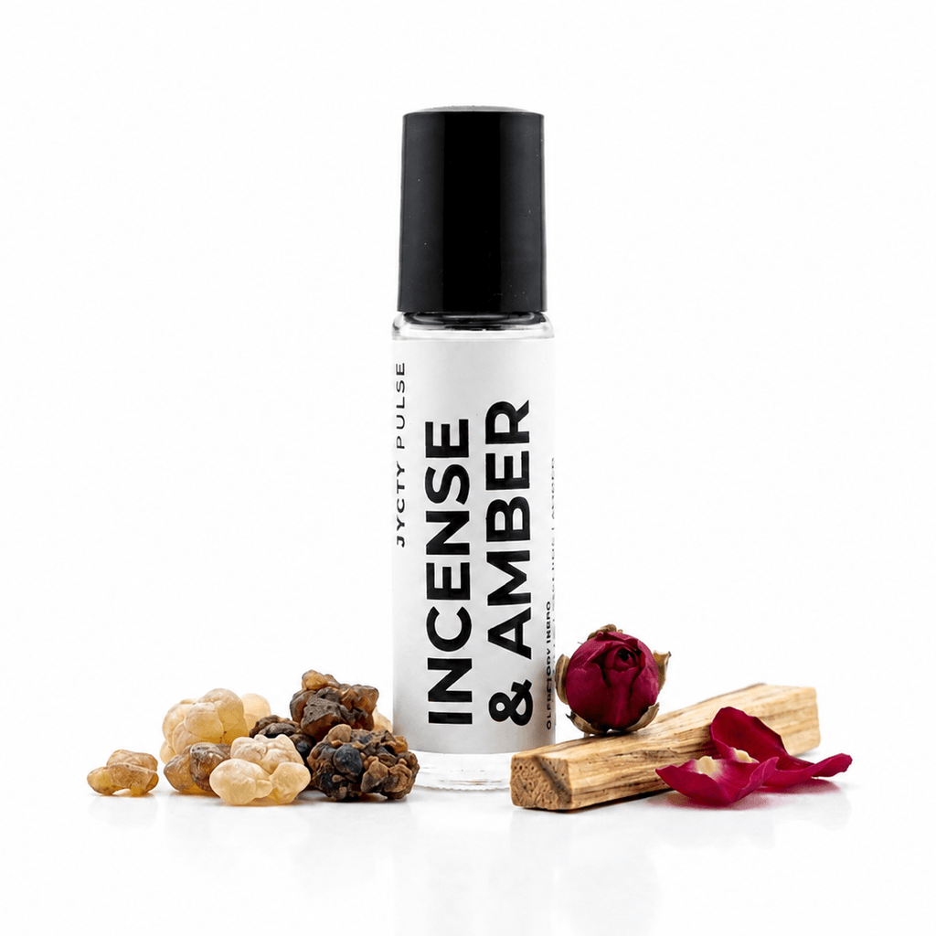 A clear glass roll-on bottle labeled 'JYCTY PULSE INCENSE & AMBER' with a black cap, styled with incense grains, a dried rose, and wooden incense sticks on a white background.