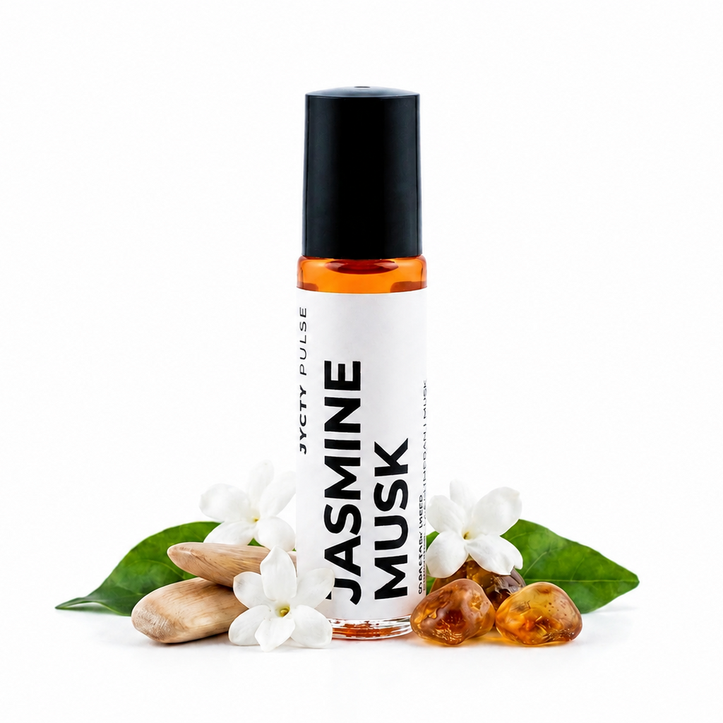 A roll-on perfume bottle labeled 'JASMINE MUSK' by 'JYCTY PULSE', featuring a black cap, white label, and amber liquid inside. The bottle is styled with white jasmine flowers, green leaves, almonds, and amber beads on a clean white background.