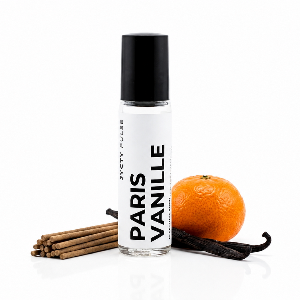A clear glass roll-on bottle labeled 'PARIS VANILLE' with a black cap, styled with vanilla sticks, a vanilla bean, and an orange on a clean white background.