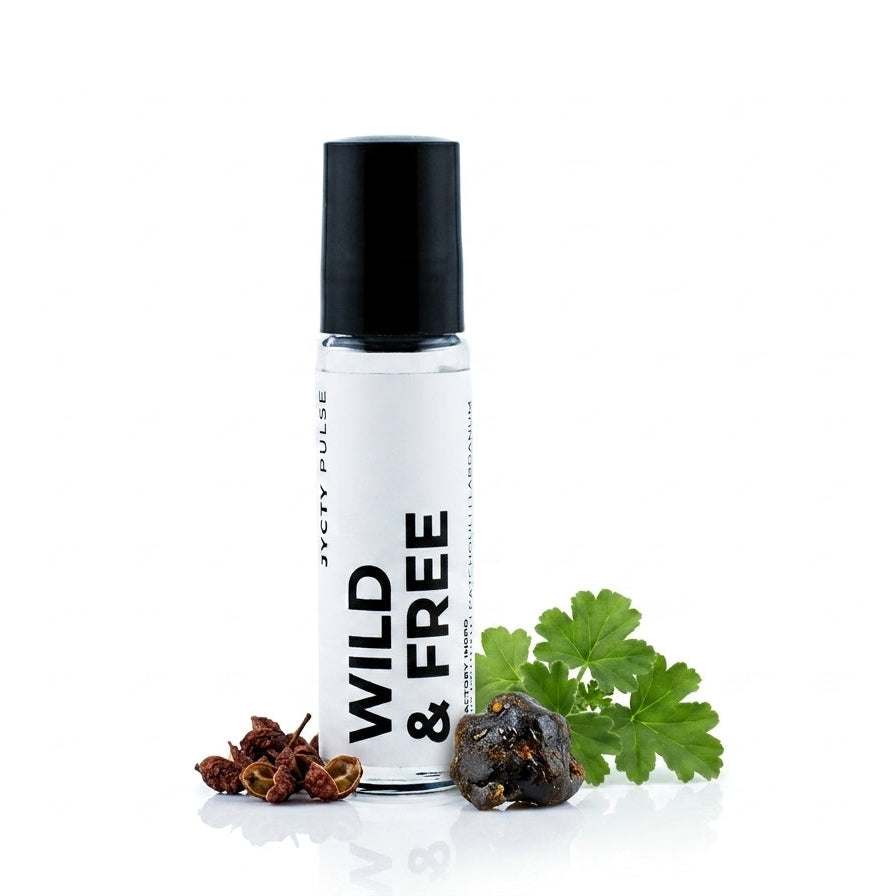 A clear cylindrical roller bottle with a black cap and a white label reading 'WILD & FREE' and 'JyctY PULSE', styled with dried red berries and green parsley on a white background.