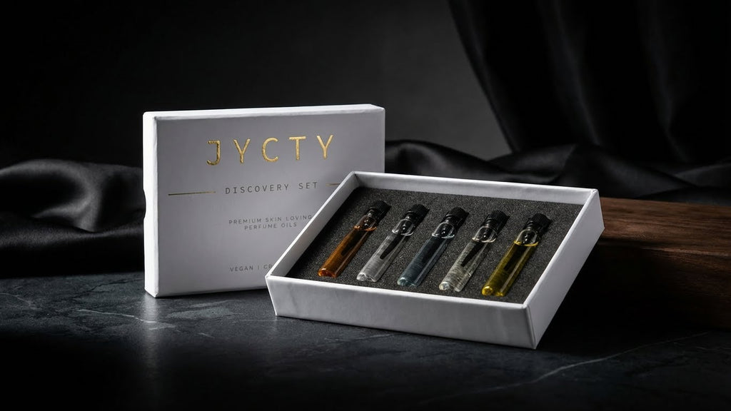 JYCTY discovery set with five small perfume oil bottles on a dark surface